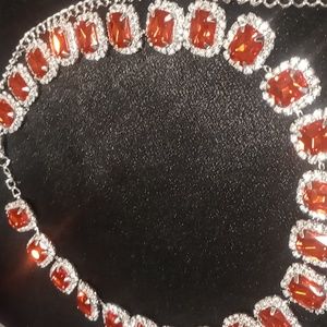Red rhinestones accented with crystal cut gems silver tone chain 14 + 6 inches.